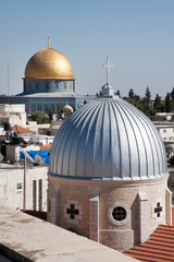 The silver dome of Our Lady of the Spasm Armenian Catholic Church and the golden Dome of the Rock rise over the Old City of Jerusalem.