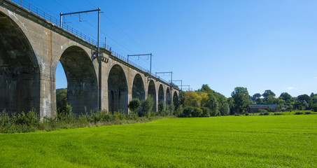 Railway viaduct along a meadow in summer