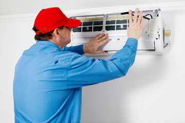 Man repairing air conditioner indoor