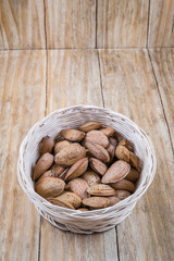 Almonds in a wicker basket on an old wood
