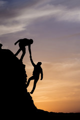 Silhouette of helping hand between two climber