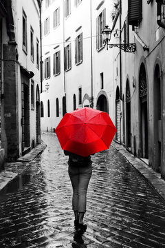 Woman With Red Umbrella On Retro Street In The Old Town. Wind And Rain