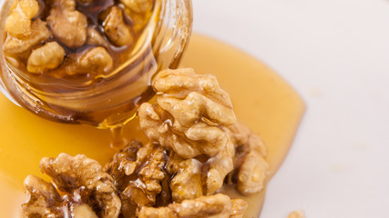 Walnut and honey dripping from jar