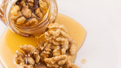 Walnut and honey dripping from jar