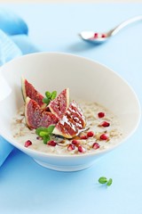 Oatmeal porridge with figs and pomegranate.Selective focus