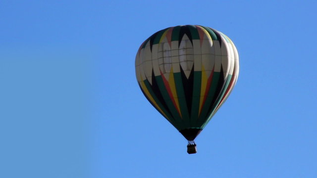 Hot air balloon floating away to right full shot