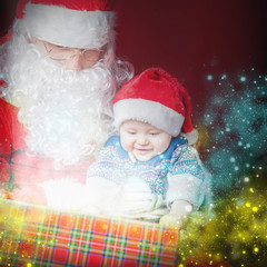 Christmas baby and Santa opening a present or gift box