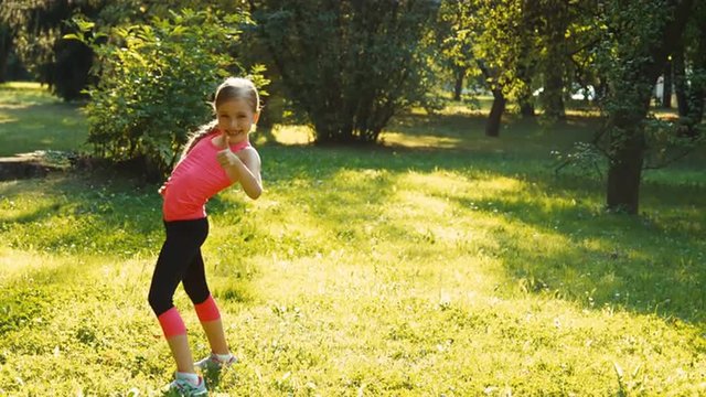 Athlete girl performing a exercise flip summersault wheel in the park at sunset