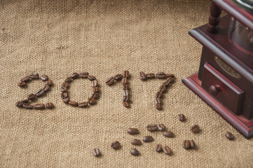 Coffee beans and coffee grinder, close up on the background of burlap sack, 2017 happy new year