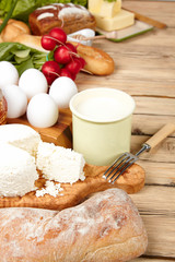 Dairy products on wooden table. Sour cream, milk, cheese, egg, 