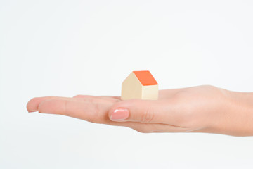 Close-up of woman's hands holding a small model house