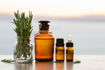 Rosemary aromatherapy essential oils in bottles on sunset 