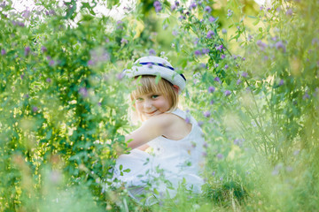 Summer portrait of cute little girl in white retro hat.