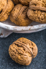 Walnuts in a white bowl on a black background