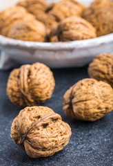 Walnuts in a white bowl on a black background