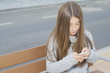 Teenage girl with long hair looking at mobile