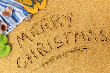 Merry Christmas message word writing written in sand on a sunny tropical beach winter holiday vacation photo