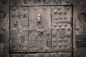 ancient wooden door spiked with several metal parts