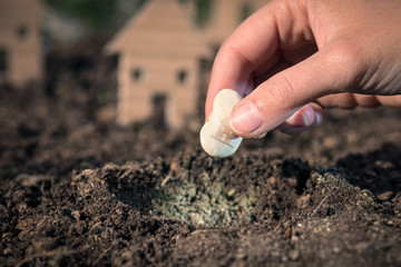 The hand is planting the seed of the house, saving and investment concept, Italy 
