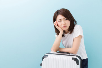 女性とスーツケース　考える