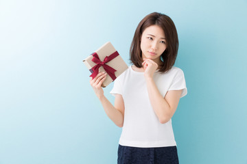プレゼントを持つ女性　考える