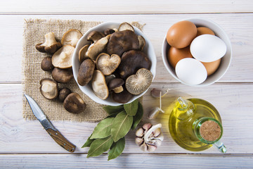 Pleorotus eryngii o setas de cardo con ingredientes para cocinar en la mesa de la cocina