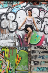 Portrait of thai adult beautiful girl relax and smile on graffiti wall
