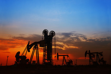 The evening of the oilfield, pumping unit and the silhouette of