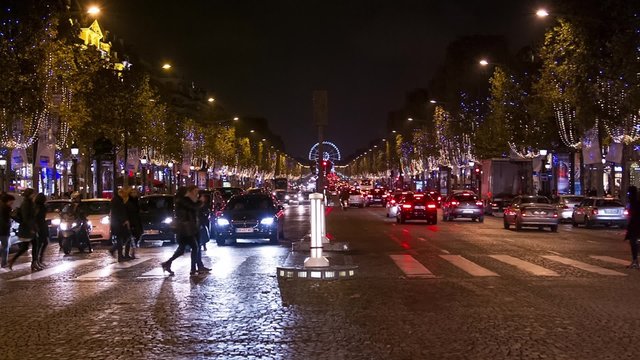 Traffic at the Champs Elysees by night 2 : The Champs Elysees by night. Cars are passing by. Christmas decoration lights are set on the trees.
