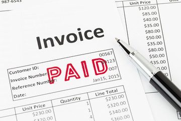 Obraz premium Invoice and pen with paid stamp; invoice is mock-up