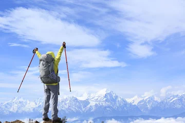 Fotobehang cheering young woman hiker open arms to beautiful snow mountain © lzf