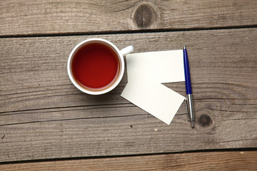 Blank business cards with pen and tea cup on wooden office table