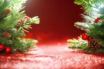 Christmas tree branches on glittering red background