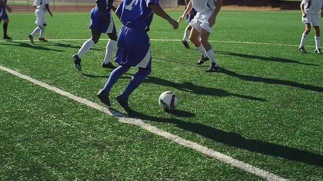 A soccer player dribbles down the field during a game
