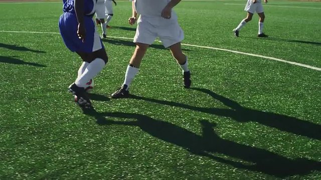 A soccer player dribbles down the field and makes a goal and then celebrates
