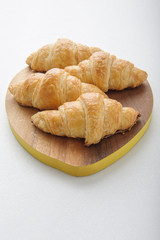 Croissant on wooden plate.