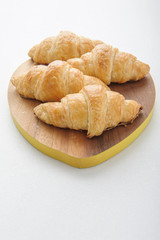 Croissant on wooden plate.