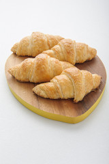 Croissant on wooden plate.