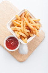 French fries with ketchup on wooden background.