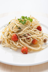 Spaghetti pasta with cherry tomatoes, basil and parmesan cheese, selective focus