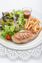 Chicken steak served with french fries and salads to vegetables.