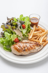 Chicken steak served with french fries and salads to vegetables.