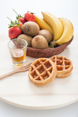 Waffles with mixed fruit and maple syrup