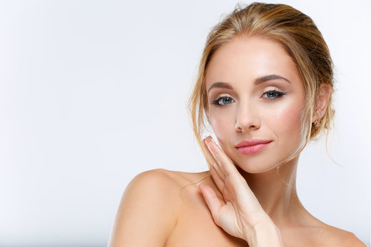 Young woman touching her face isolated on white background