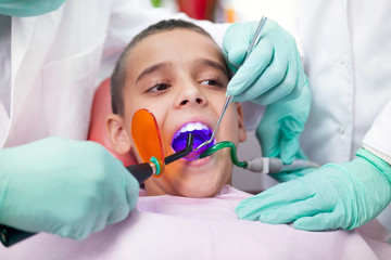 Close up of boy having his teeth examined by a dentist