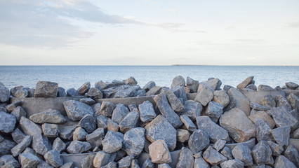 Fototapeta na wymiar Stone embankment to prevent the waves of the sea.