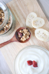 granola on spoon with yogurt bowl