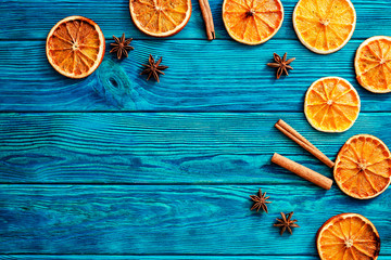 
blue wooden background with orange , cinnamon and spices