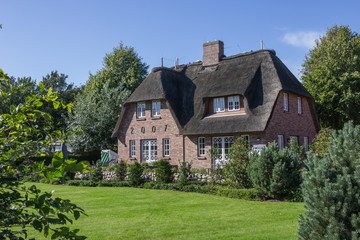 Fototapeta na wymiar Reetdachhaus mit großem Garten
