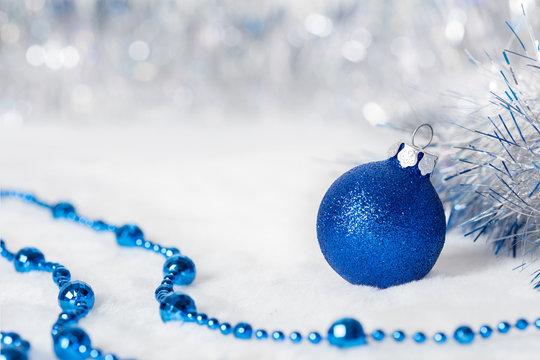 Blue Christmas ball with beads. Bokeh with glow effect on white background. Copyspace for your greeting or wishes